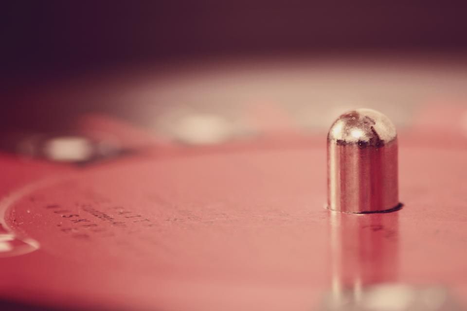 The spindle of a turntable in warm red light